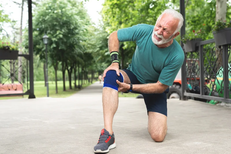A man with Sjogren’s Syndrome is suffering from joint pain while outdoors