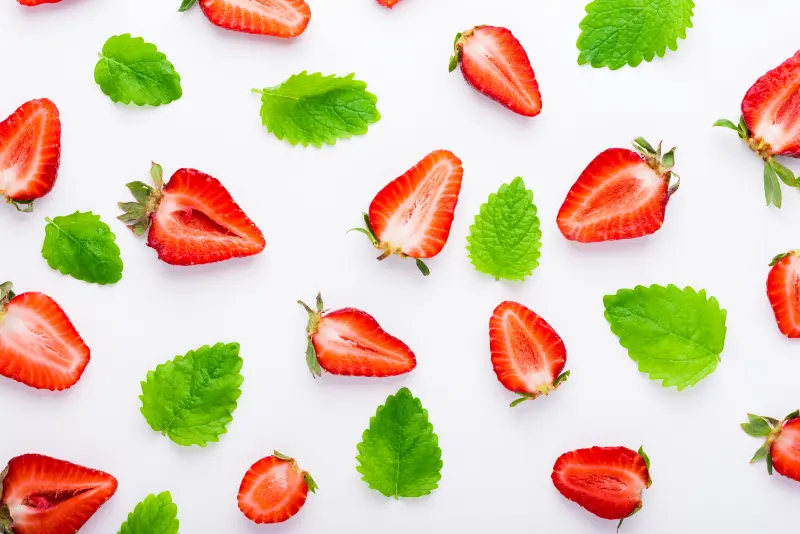 Strawberries and mint leaves to represent flavor options of Lubricity Xtra as a saliva substitute alternative to dry mouth gel