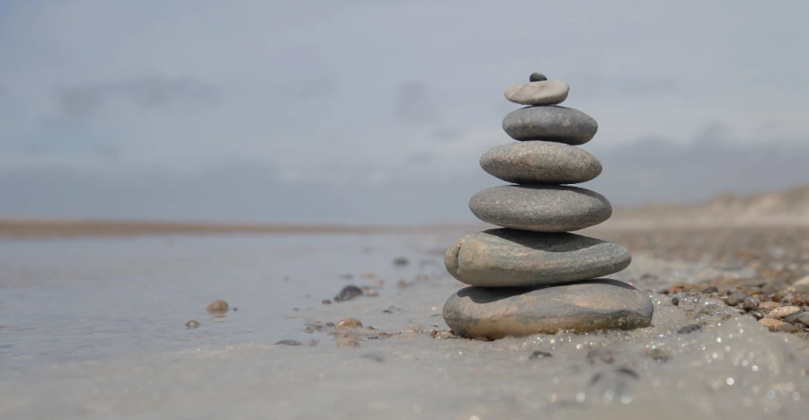 Stones balancing by the water to represent the balance between nasal breathing and breathing through mouth to live a healthy life.