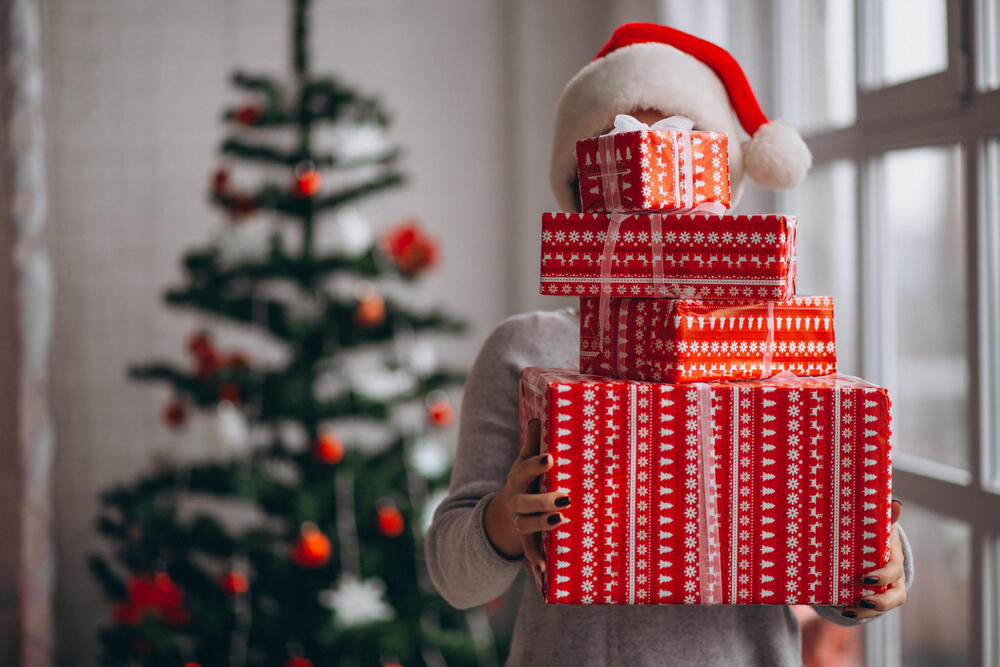  A lady holding boxes of presents hoping that one holds moisturizing oral spray.