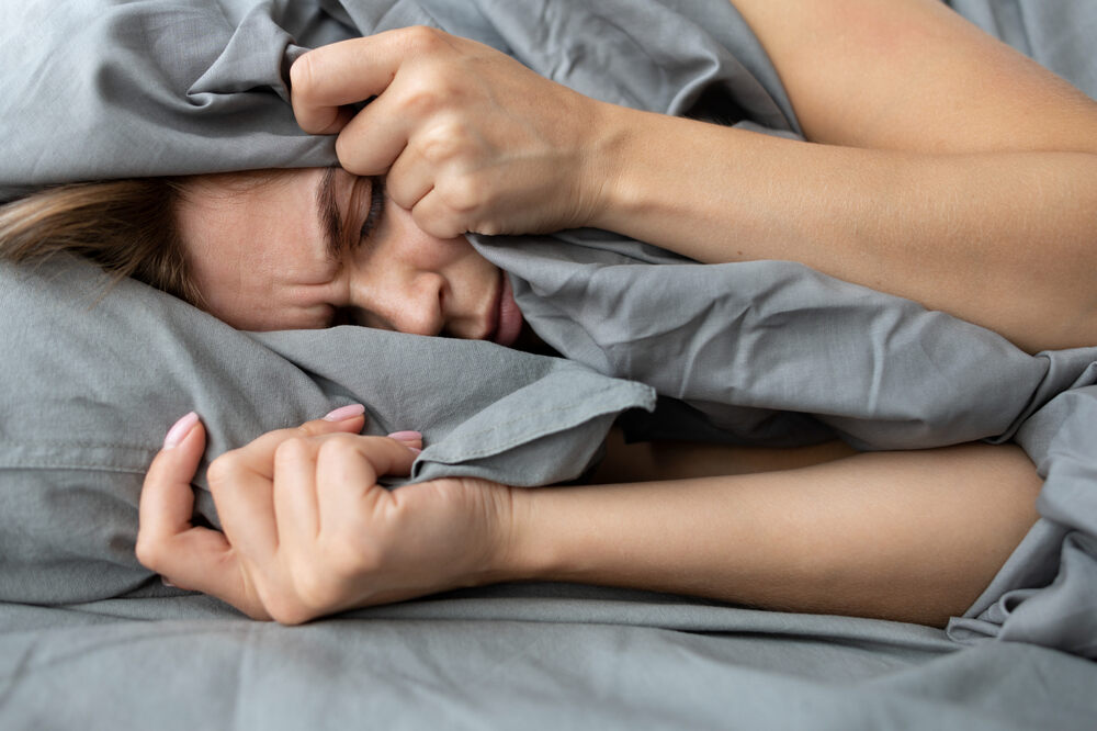 A lady with cotton mouth discomfort struggling to fall asleep as a result.